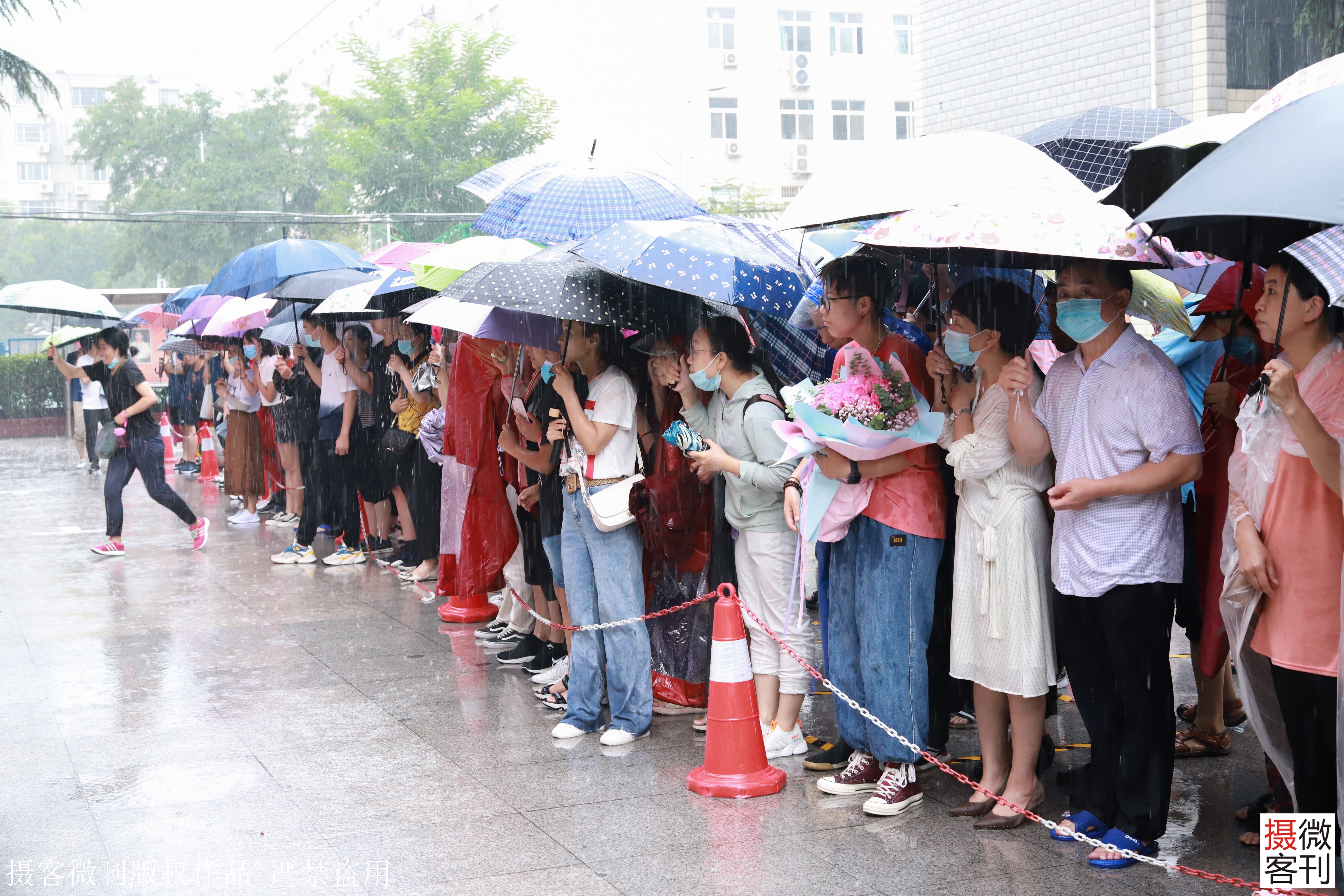 一场大雨为高考画句号,郑州考场外家长一手打伞一手抱