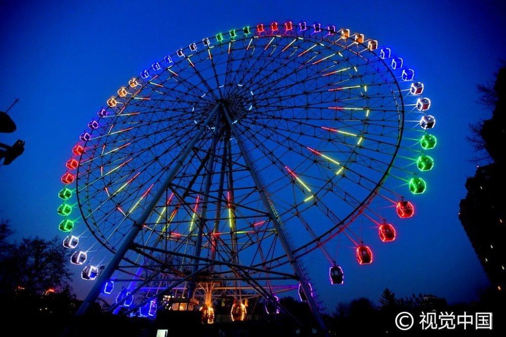 闪烁的彩灯点缀着转动的摩天轮,在夜空的映衬下,显得格外美丽,仿佛