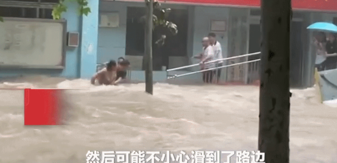 洪水中,一位市民被湍急的水流冲走,眼看就要掉进前方的水坑.