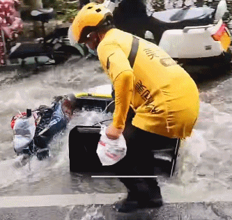 暴雨过后水流湍急,外卖小哥一手拎着外卖,一手紧紧抓住被水冲走的电动