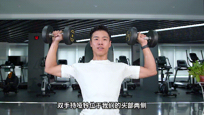第三步:深吸一口气,将哑铃分别从身体的两侧推起,相交于头部的正上方