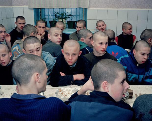 图为一些少年犯,正等待着监狱狱警给他们送来饭.