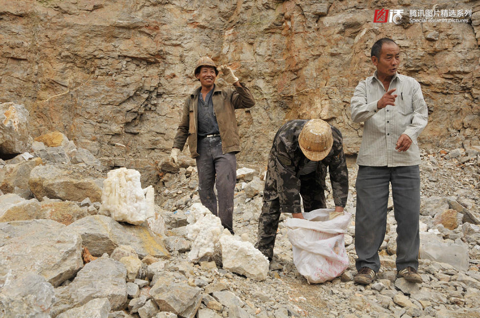 几名采石场工人从溶洞内搬出采挖的钟乳石.