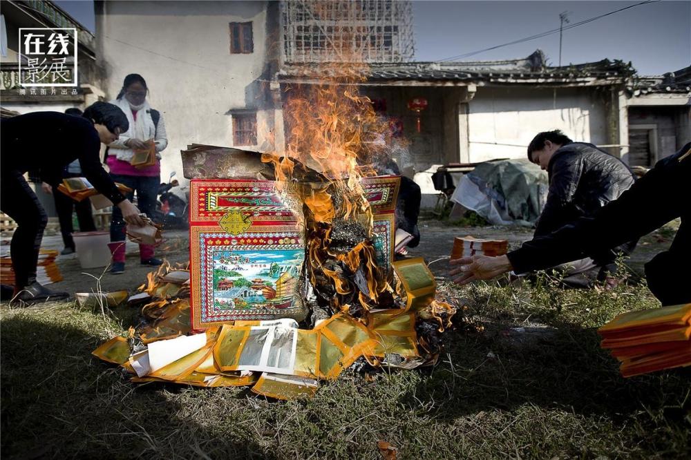 家公去世一年后,在外地的孩子们都赶回来在家门前的空地上烧纸钱祭品