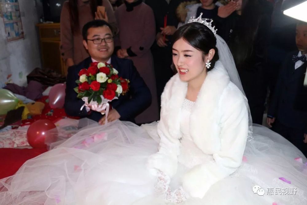 图中的新娘面朝东北而坐,即使在新郎献手捧花时,背对新郎,也要讲究