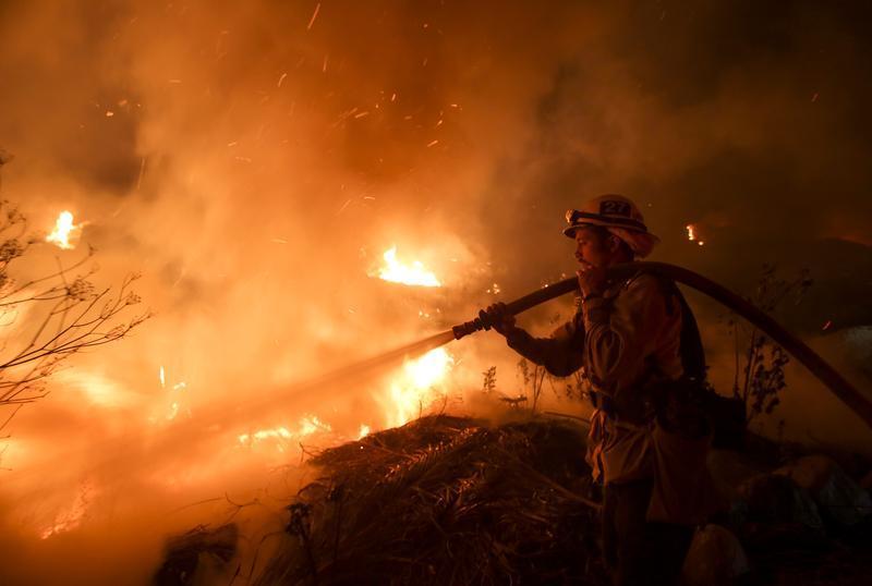 图说:12月5日,消防员在圣保拉的林火现场灭火.新华社