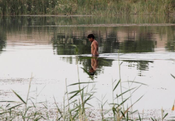图为一名男孩在河里游泳