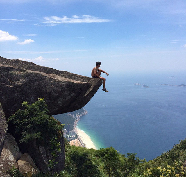 旅行者卢卡斯·麦特斯(lucas mattos)坐在悬崖边上拍照.