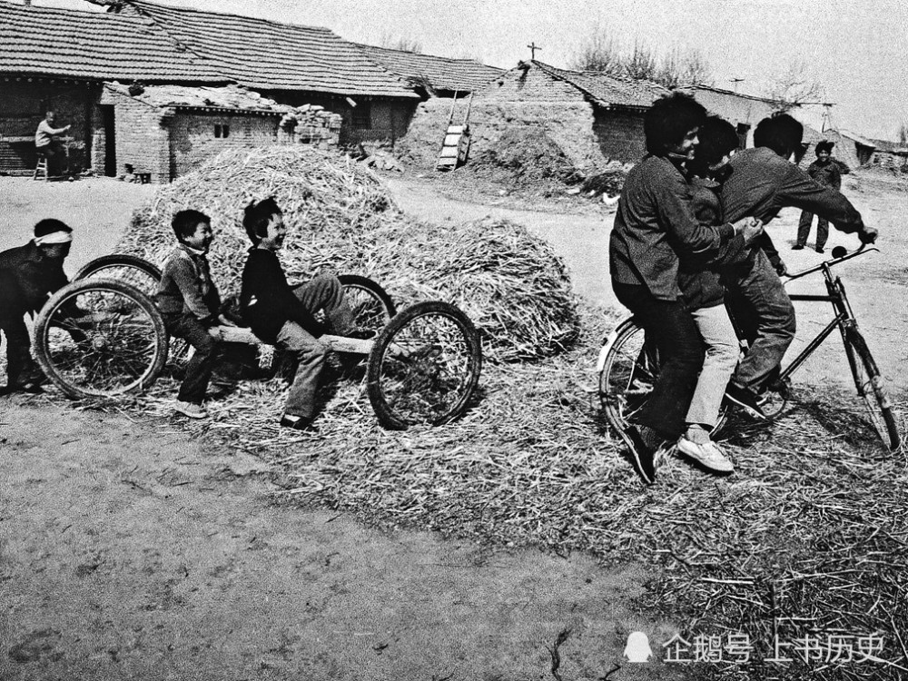 1990年,骑自行车及坐平板车车轮玩耍的乡村少年.