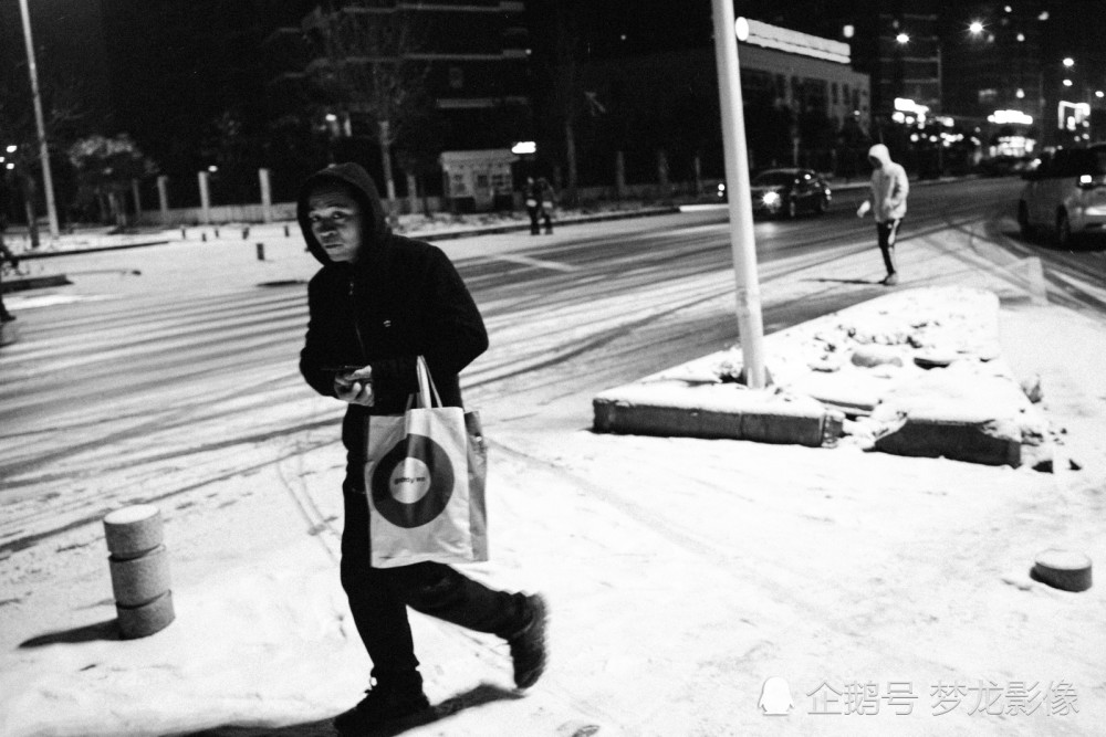 1.26日,摄影师拍摄了一组夜间在风雪中赶路的行人.