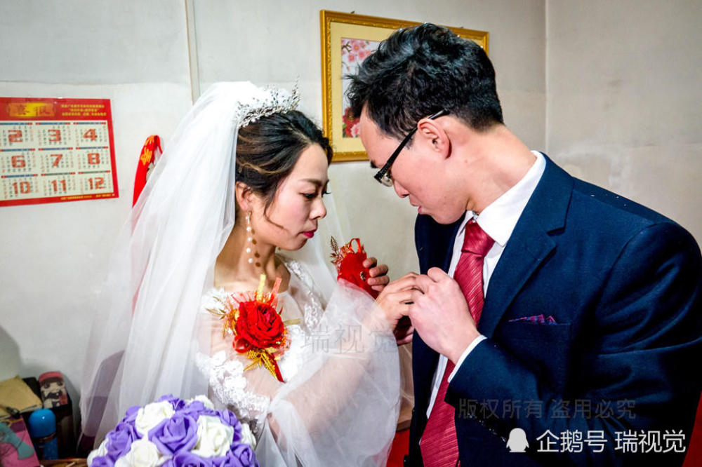 新娘为新郎佩戴"新郎"花.新郎为新娘佩戴"新娘"花.