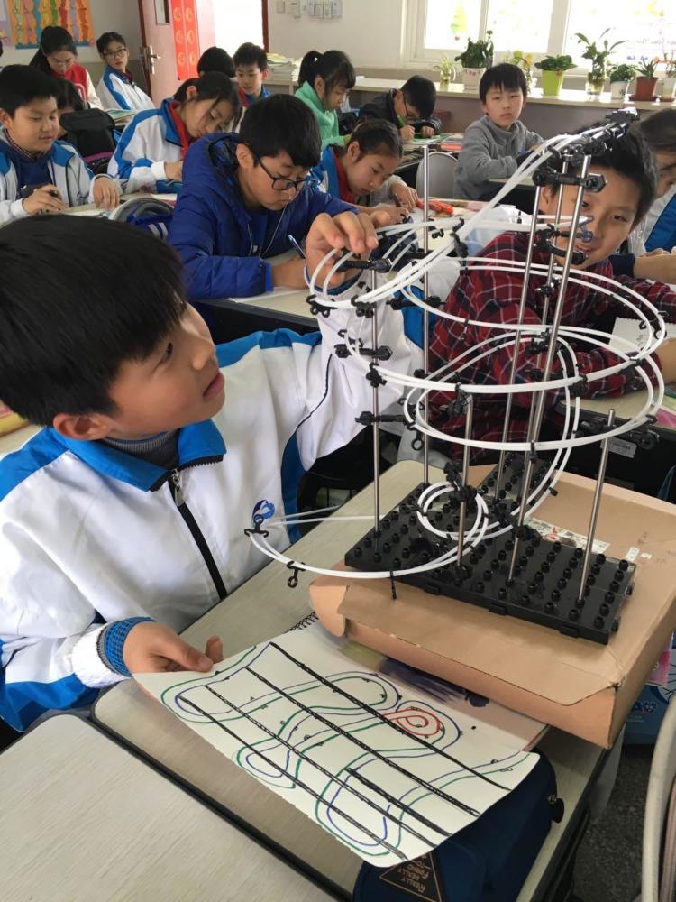 课上,老师指导同学们根据自己的设计图制作出属于自己的过山车轨道
