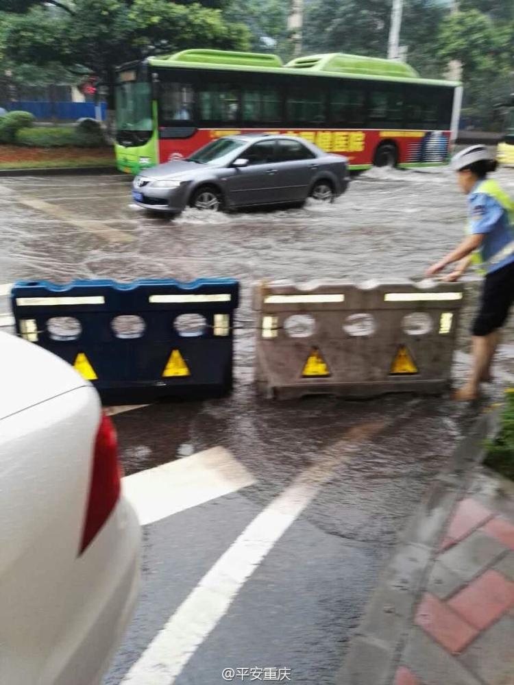 重庆暴雨袭城 女交警赤脚推开抛锚汽车_腾讯网