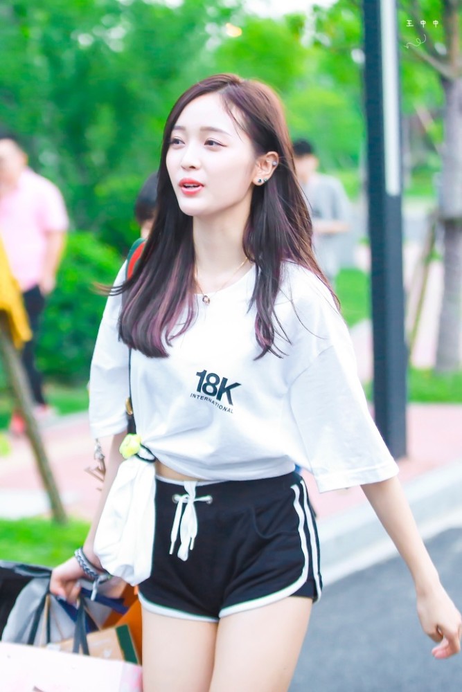 吴宣仪穿白色T恤搭配黑色短裤现身面带微笑,用