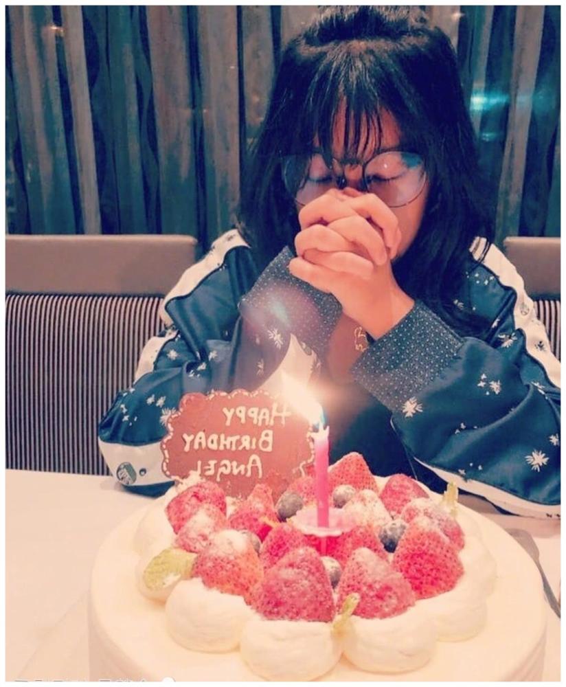 照片中,13岁的小女孩吴彤·梅双手合十在生日蛋糕上许愿.画面很温暖.