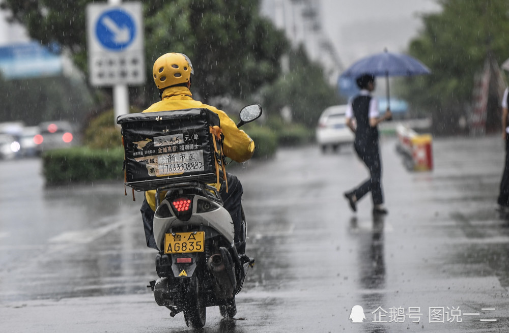 一位外卖小哥在雨中前行.