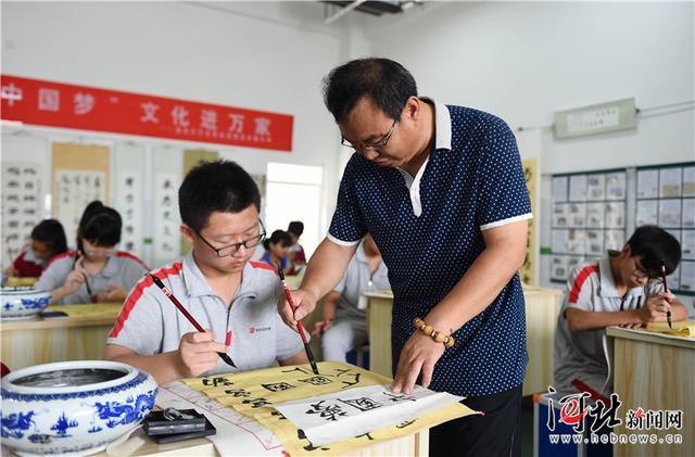 6月29日,南宫市丰翼中学学生在书法教师指导下练习省级非遗项目南宫