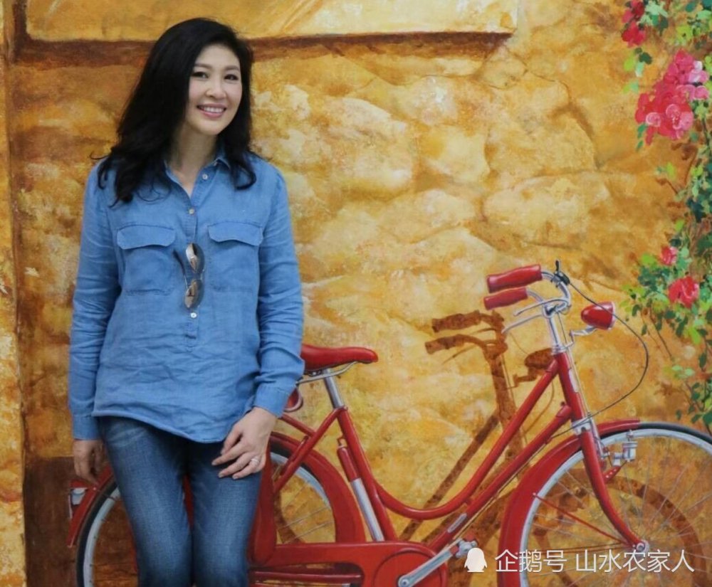 泰国上一任美女总理英拉罕见生活照:与自行车合影,与百姓拍照!