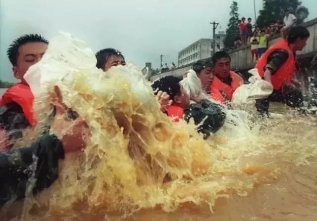 为迎战第五次洪峰,抗洪部队竭尽全力运送沙袋,死保大堤.