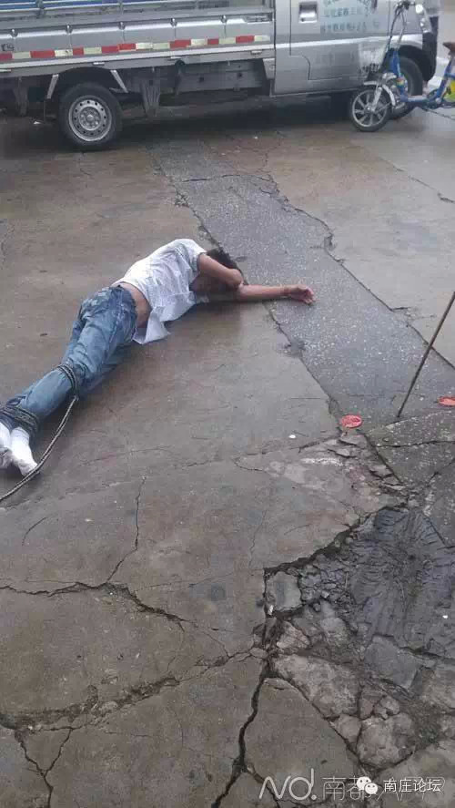 砍人者被民众合力制服,双腿被捆绑住. 目击者供图