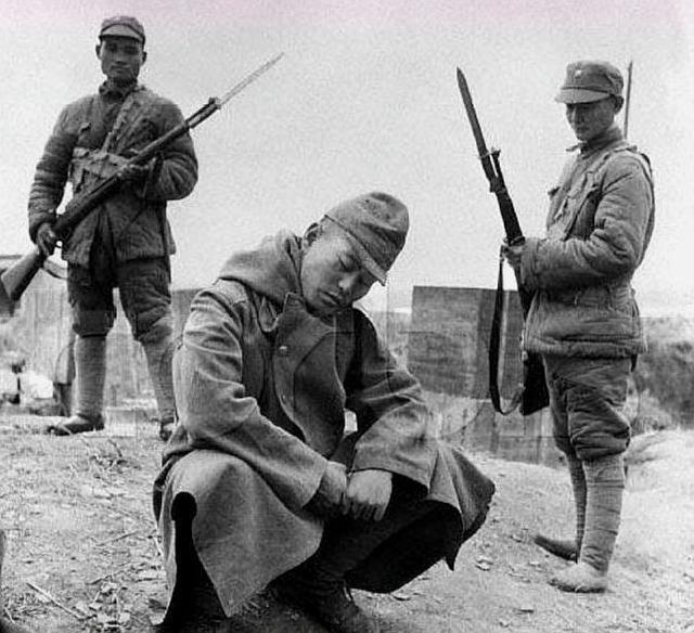 历史老照片,照片中的鬼子蹲在地上昏昏欲睡,完全没有把中国士兵放在