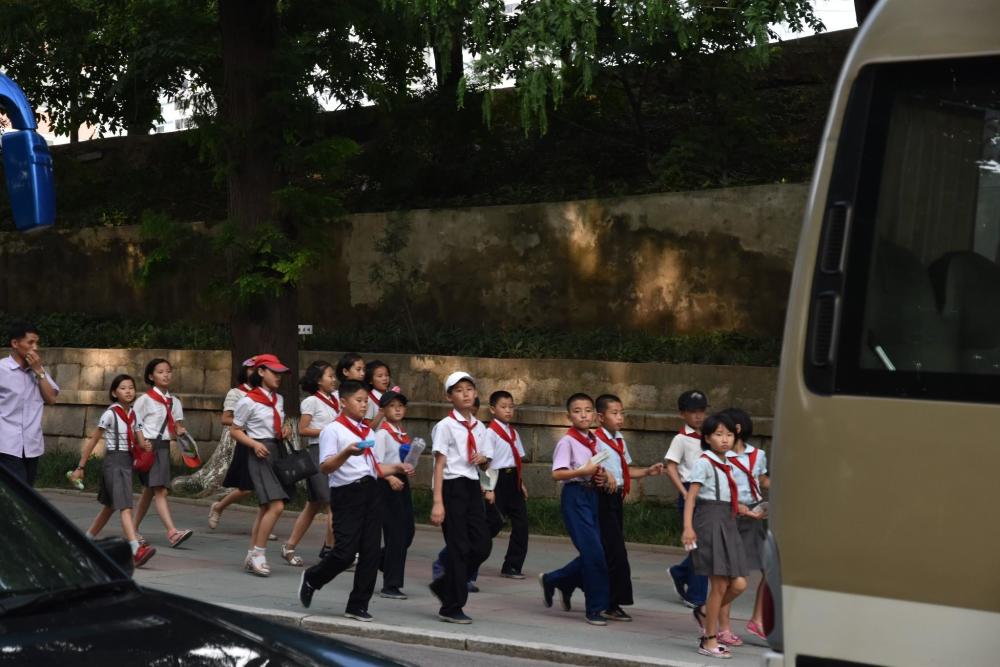 图为一群戴着红领巾的朝鲜小学生,他们正集体外出游玩.