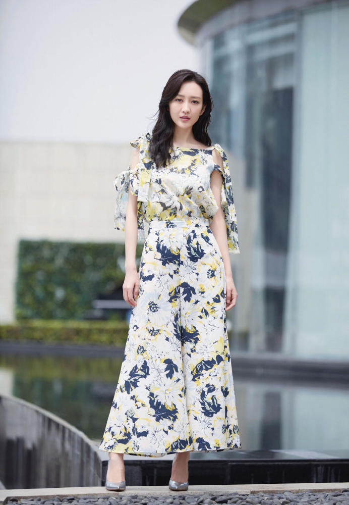 王鸥脚踩黑色凉鞋,身穿一条及膝衬衫裙,简约随