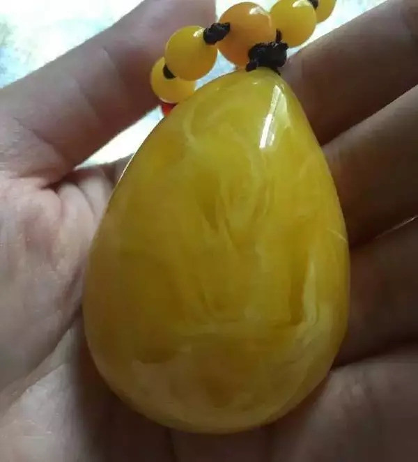 而如果从纹理上来讲 天然蜜蜡具有天然的流淌纹 而塑料与二代蜜蜡则不