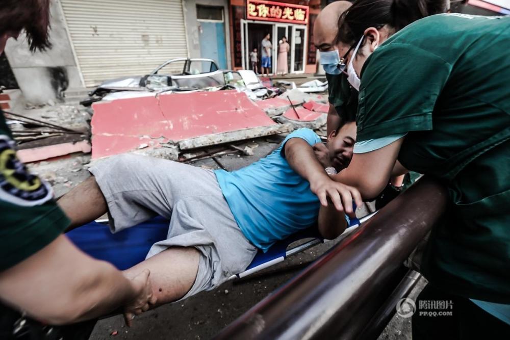 骑电动车路过的市民为左腿受伤,120急救人员赶到现场救治伤者.