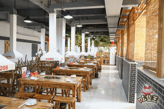 二楼的地方更大,还有一棵树的装饰,搭配木质的桌椅,青灰色的石砖