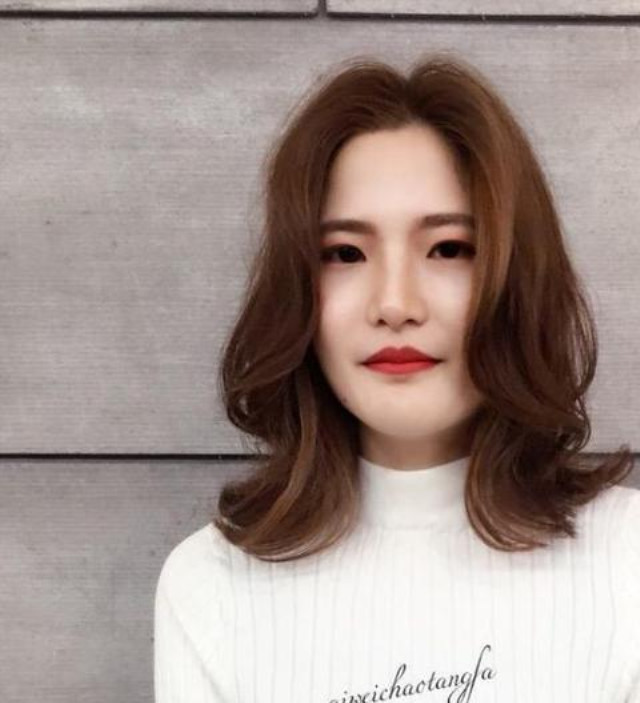 "烫翻翘"修饰脸型之余更衬托出女生尖细的下巴,加上女生身上知性气质