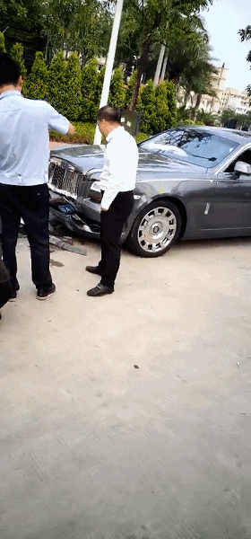 而劳斯莱斯车头损毁程度也不轻, 连车牌都被撞凹进去了