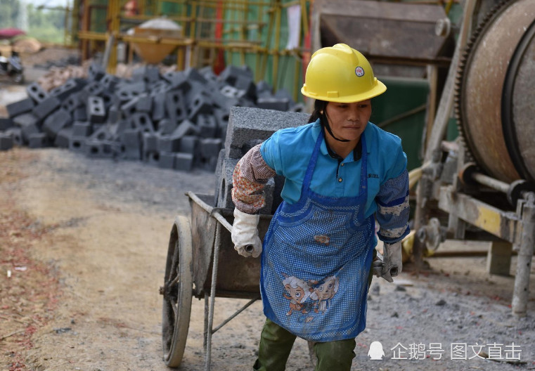在广西罗城仫佬族自治县"仫佬家园"工地上,一位农民工母亲正在搬砖