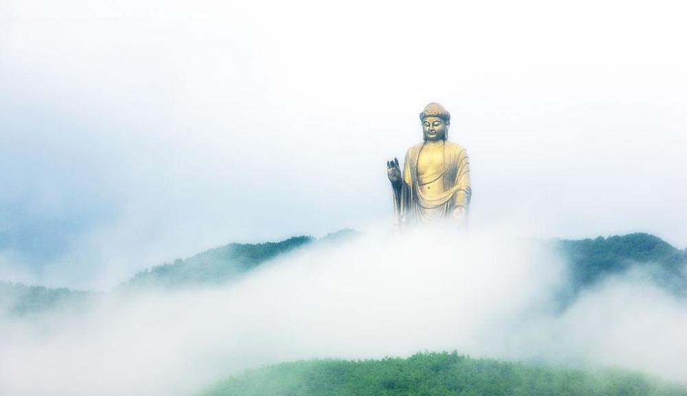 云雾缥缈中的尧山大佛,可见其高耸入云,俯瞰众生之象,彰显佛光庇佑.