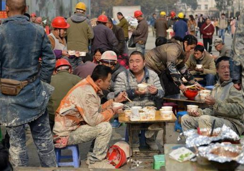 成都的一处工地附近,身上沾满泥水的农民工兄弟正在吃饭,9块钱管饱