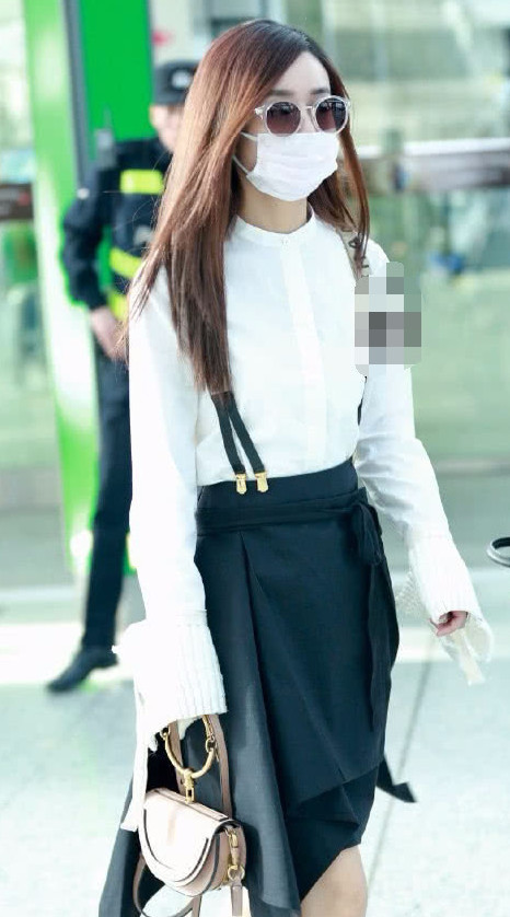 这一次赵丽颖身穿一件白色衬衫搭配黑色裙子现身机场
