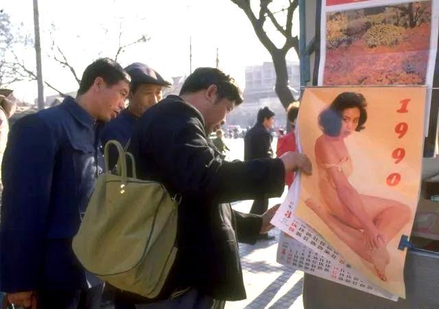 1990年的街头挂历市场,几位大叔正在翻看.