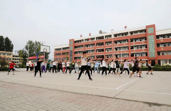 学生在内黄县东庄镇第一初级中学综合楼前活动