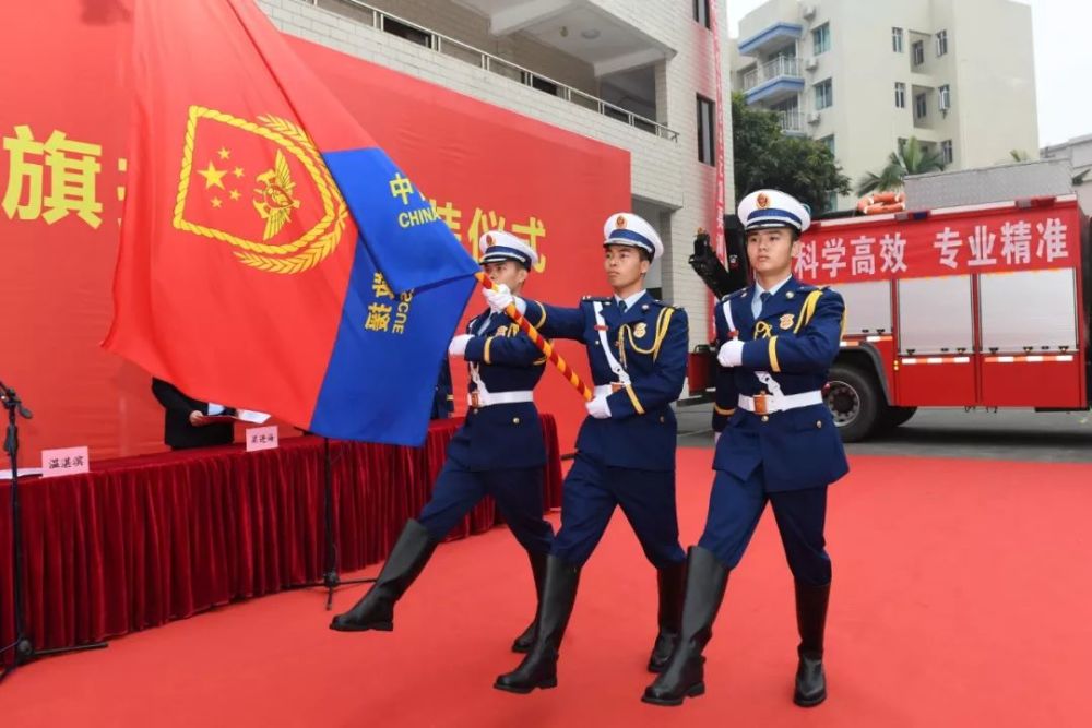 红蓝相间的崭新旗帜在迎风飘扬 身着全新"火焰蓝"制服的消防指战员们