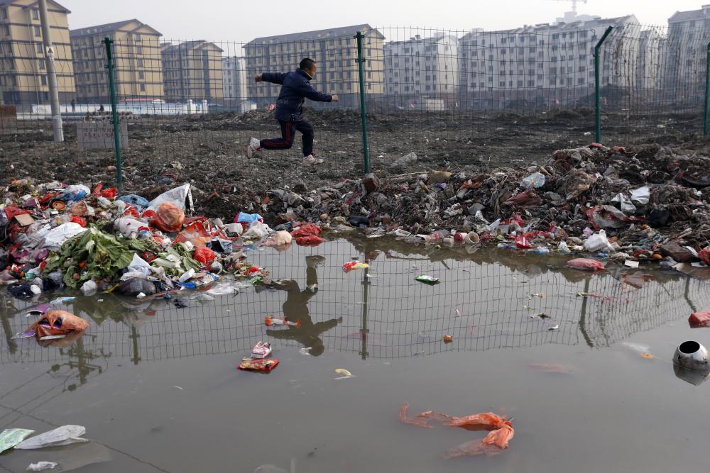 江南水乡一处安置房前的河道布满生活垃圾.