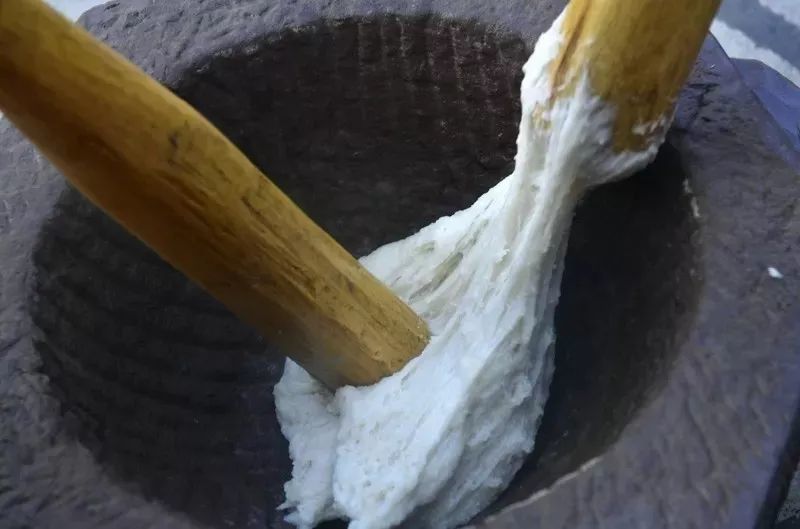 糍粑由糯米蒸熟再通过特质石材凹槽冲打而成,手工打糍粑很费力,但是