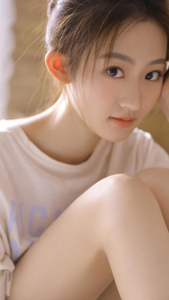 扎着丸子头的一位美女,大大的眼睛,翘翘的鼻梁,五官轮廓很精致,显得