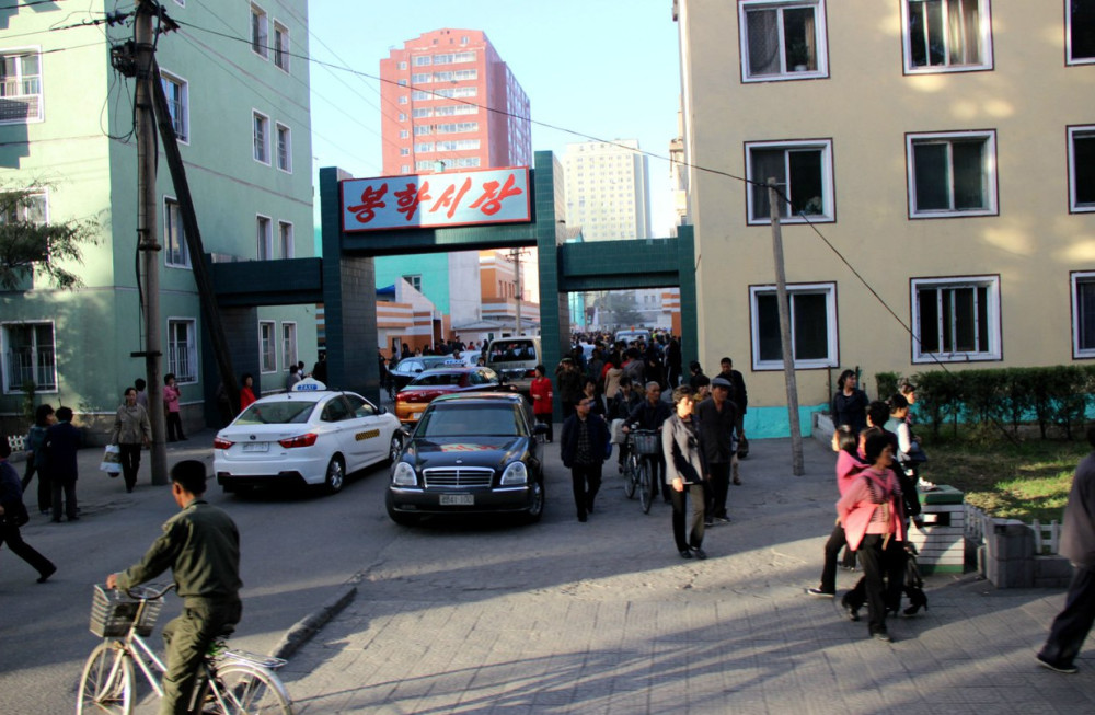 图为朝鲜平壤的街景,街头的汽车很多,行人也非常多.