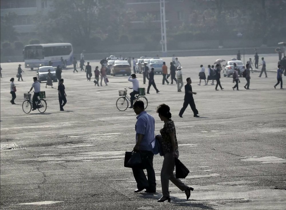 图为朝鲜街头的路人,有人 步行,有人骑自行车.