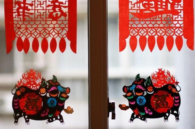 此外,在天津,河北等地还有"肥猪拱门"的节日窗花,这窗花是用黑色