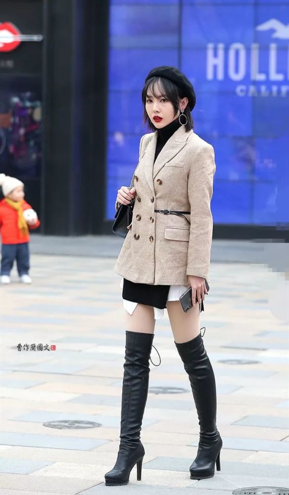 街拍:春日里穿短裙搭配高筒靴的美女