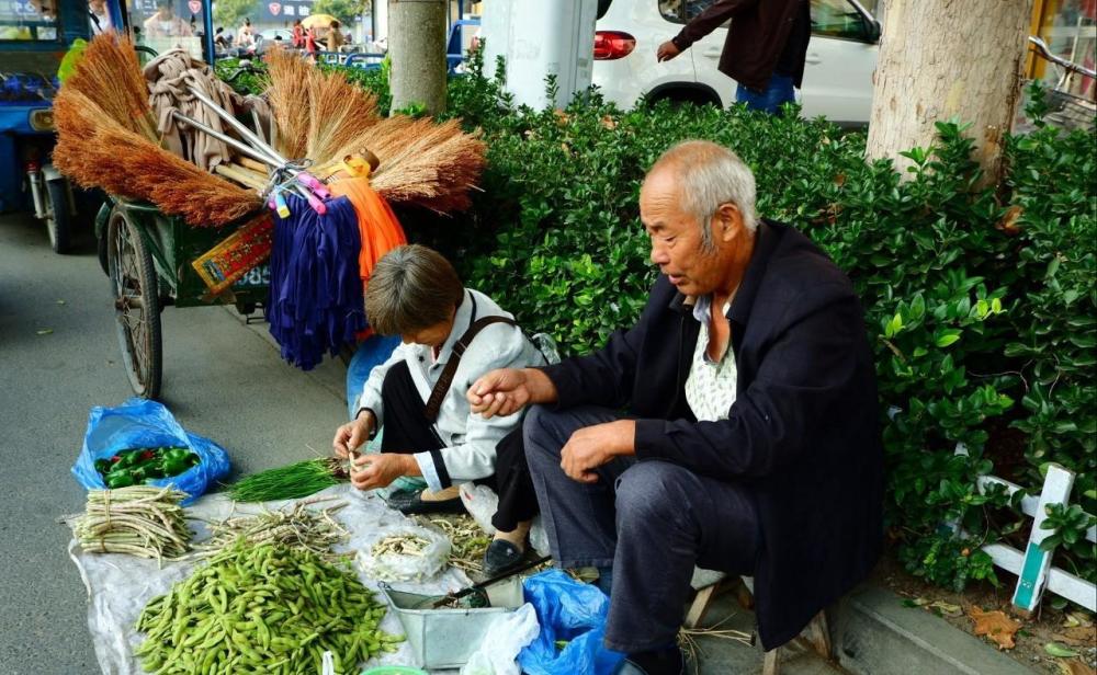 街边菜市场,大爷大妈在卖菜,挣钱不易,就怕城管