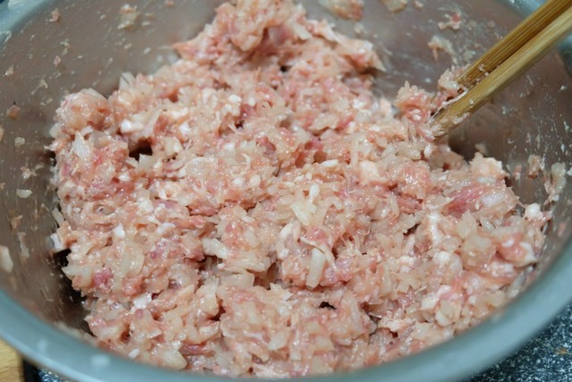 7,再把切碎的白萝卜和拌好的猪肉馅混合在一起,搅拌均匀,饺子馅就制作