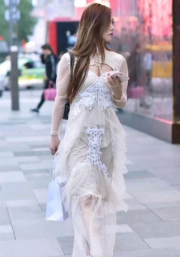 街拍:美女穿条米色长裙,透露着知性美,在街头显得清纯