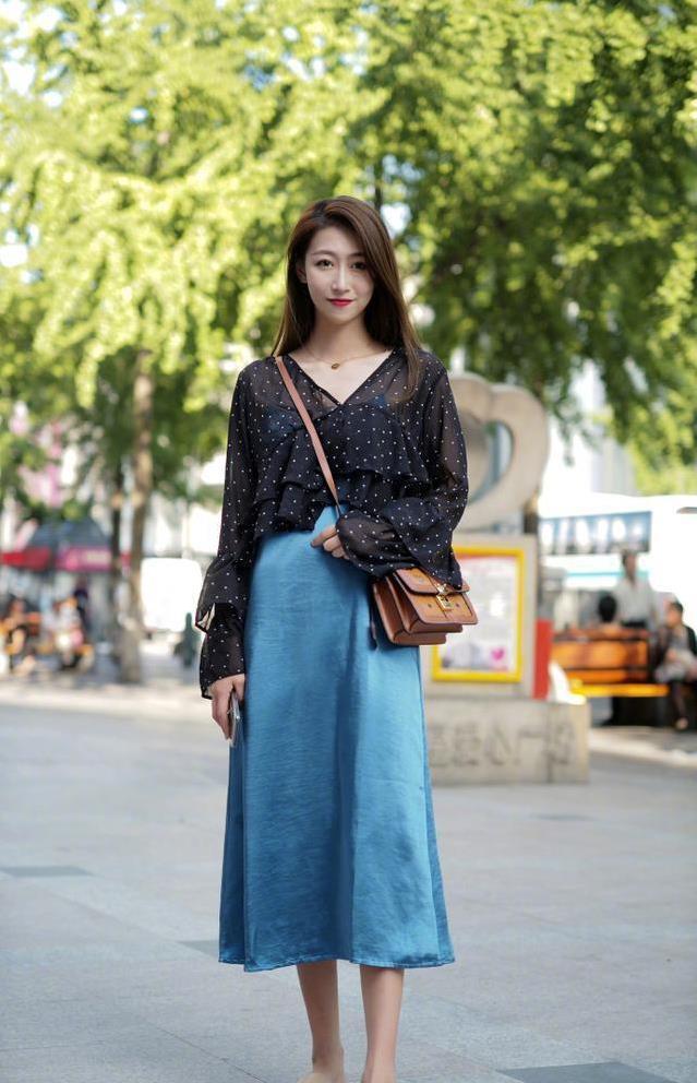 v领上衣 蓝色半身裙的美女,站姿亭亭玉立楚楚动人.